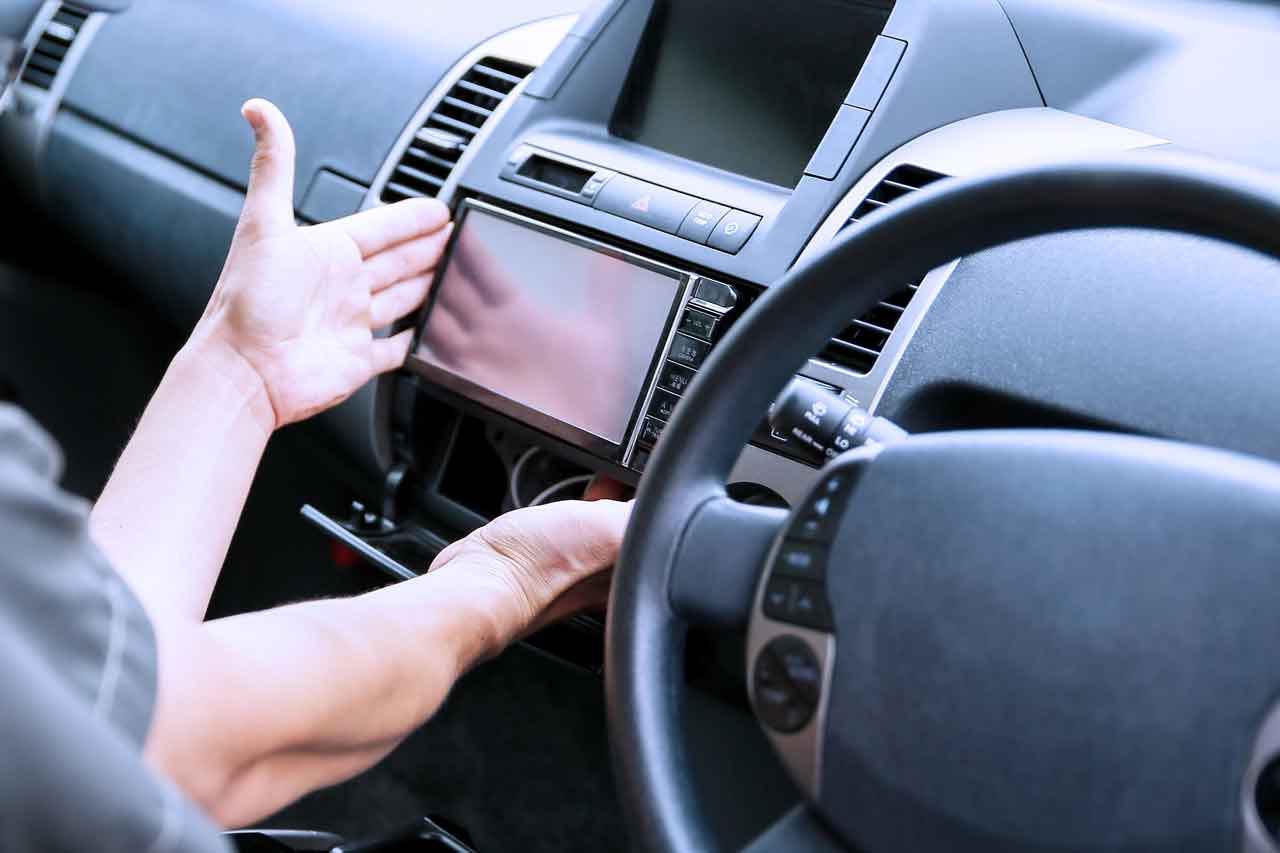 自動車のダッシュボードにカーナビゲーションシステムを取り付けている様子